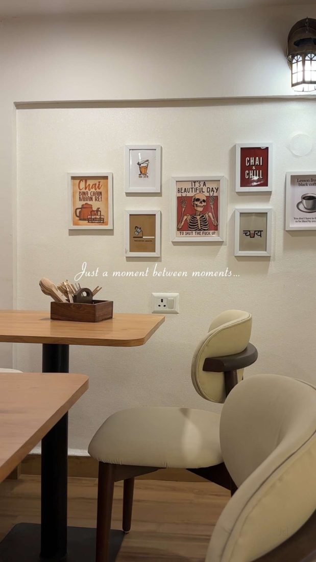 Café corner with framed chai posters and cream chairs